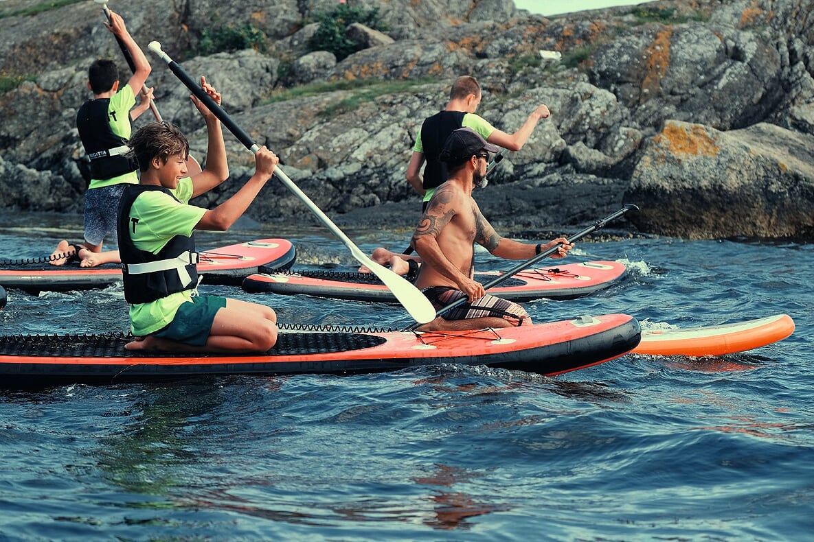 Øvelser på Stand-Up-Paddleboard (SUP) ved Emmausstranda. Erlend Ruud-Larsen, Aslak W. Friestad og Mattias Fagerland. Foran til høyre instruktør Migel Angel Sanches Origel fra Myggen Surf School.